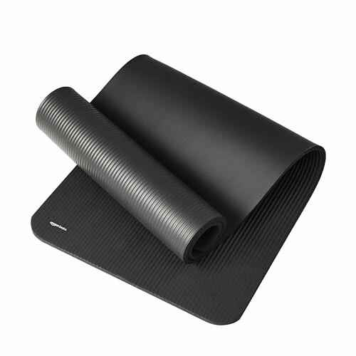 Rolled black yoga mat on white background