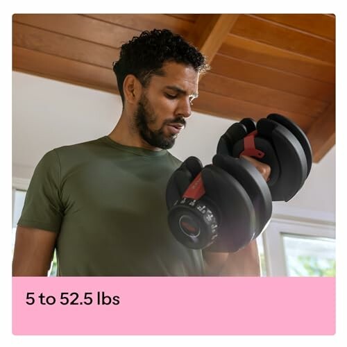 Man lifting an adjustable dumbbell indoors.